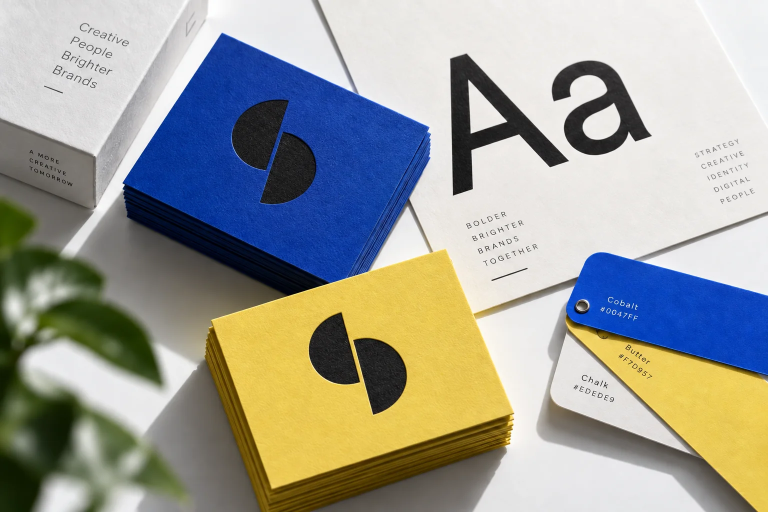 Cobalt and yellow print samples showing typography, colour and an embossed brand symbol